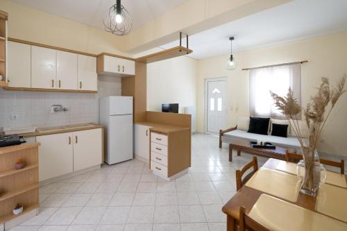 een keuken met een koelkast, een tafel en een bank bij Foto's apartment in Lixouri