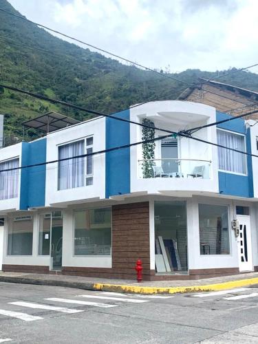 um edifício azul e branco com uma boca de incêndio à frente em AHAVAH SUITES em Baños