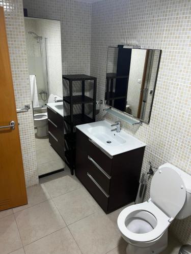 een badkamer met een toilet, een wastafel en een spiegel bij Casa del tiempo in Vecindario