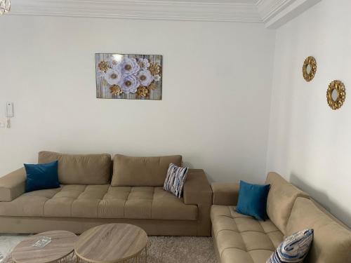 a living room with a brown couch and a table at Magnifique Appartement Vue Mer in Nabeul