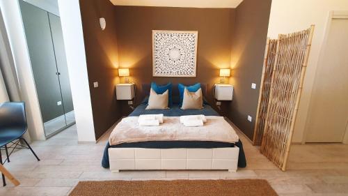 a bedroom with a large bed with blue pillows at Apartment Giotto Eremitani in Padova
