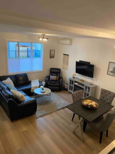 a living room with a couch and a table at Adorable 1 Bedroom Suite- a skip to Galloping Goose in Victoria