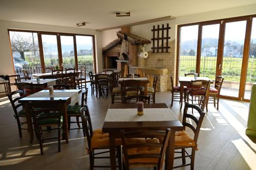 a restaurant with tables and chairs and windows at Agriturismo A Casa Mia Gubbio in Gubbio