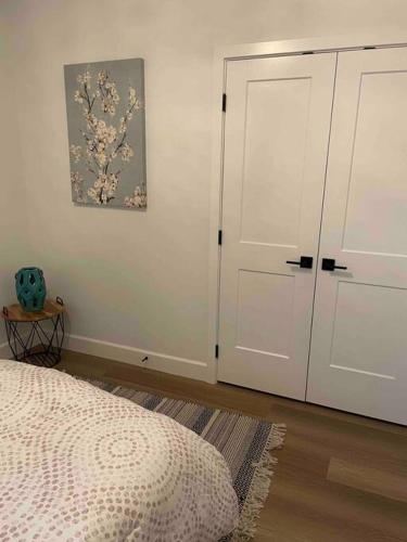 a bedroom with a bed and a white door at Adorable 1 Bedroom Suite- a skip to Galloping Goose in Victoria