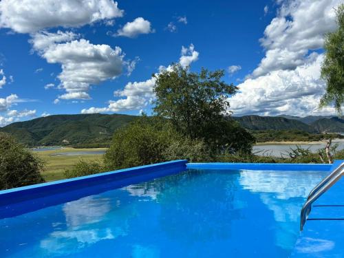 a swimming pool with a view of the mountains at Punta Sur - Dique Cabra Corral in Coronel Moldes