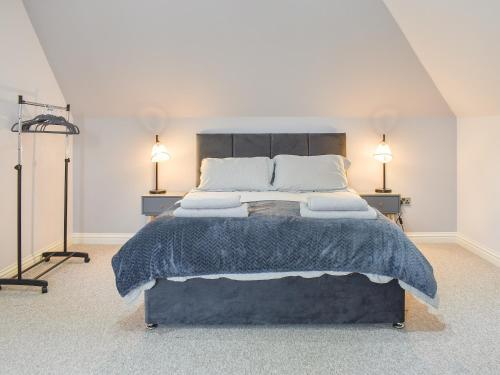 a bedroom with a large bed with two lamps at The Lodge in Cosham