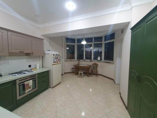 巴库Central Park apt with a nice view的厨房配有绿色橱柜和桌子
