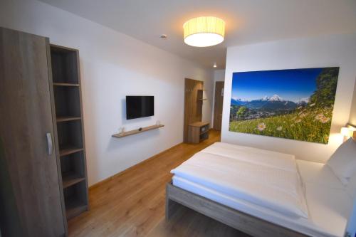 1 dormitorio con 1 cama y una pintura en la pared en Sporthotel Zederhaus en Zederhaus