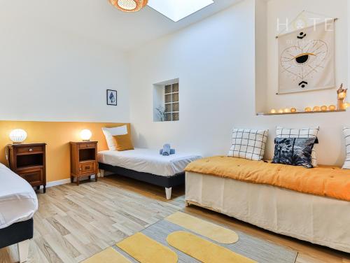 a room with two beds and a clock on the wall at Maison de surfeurs, idéalement située in Les Sables-dʼOlonne