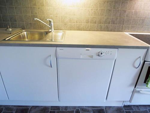 una cucina con lavandino e lavastoviglie bianca di Charming house by the sea, Lofoten! a Laupstad
