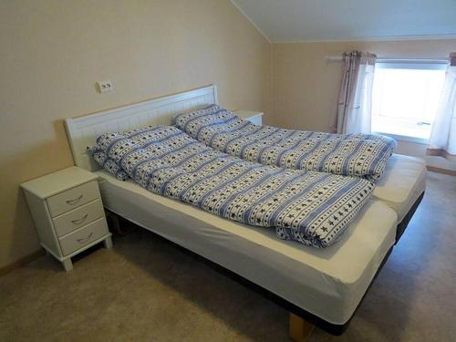 un letto con due cuscini sopra in una camera da letto di Charming house by the sea, Lofoten! a Laupstad