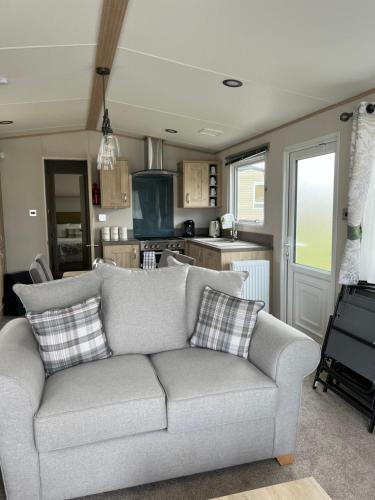 a living room with a couch and a kitchen at Sea La Vie in Cayton