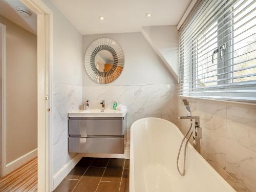 a bathroom with a sink and a mirror at Brittons Hill Cottage in Wavehorne