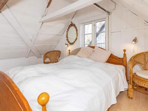 Un dormitorio con una gran cama blanca y una ventana en Holiday home Præstø V, en Præstø