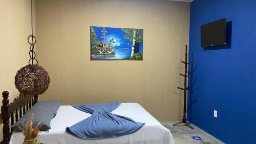 a bedroom with a bed with a blue wall at Milagres Retrô- Studio in São Miguel dos Milagres