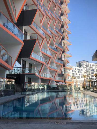 a building with a swimming pool in front of it at Hayyak Homes-Luxury 1 bedroom Apartment in Dubai