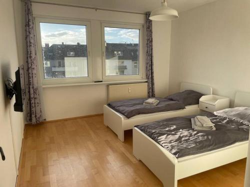 - 2 lits dans une chambre avec 2 fenêtres dans l'établissement Ruhig und zentral wohnen! MA3R, à Essen