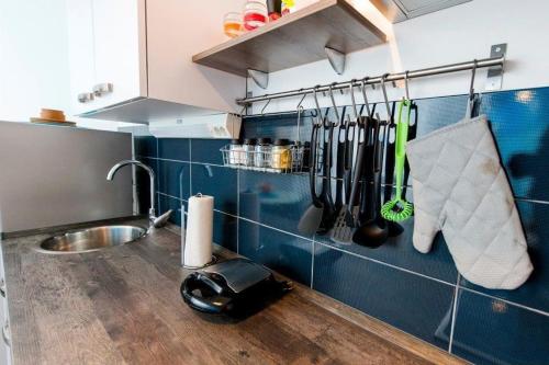 een aanrecht met een wastafel en keukengerei aan de muur bij Apartman Puzzle in Rovinj