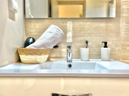 a bathroom sink with a towel and a basket on it at Marrakech golf City prestigia in Marrakesh