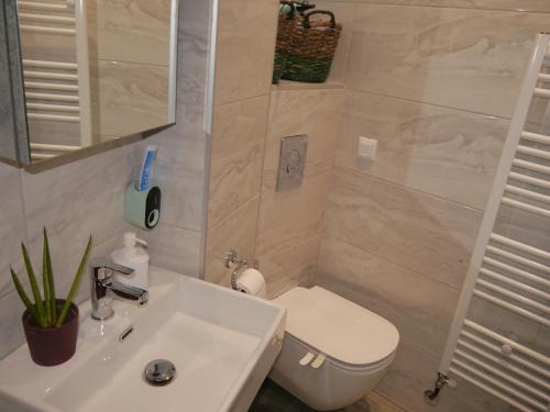 a bathroom with a white sink and a toilet at Cozy & Stylish Eastside Apt. in Thessaloniki