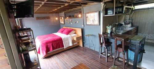 Habitación con cama y cocina en un remolque en Glamping Montecarlo Lodge Cubo de Madera-Guatapé, 