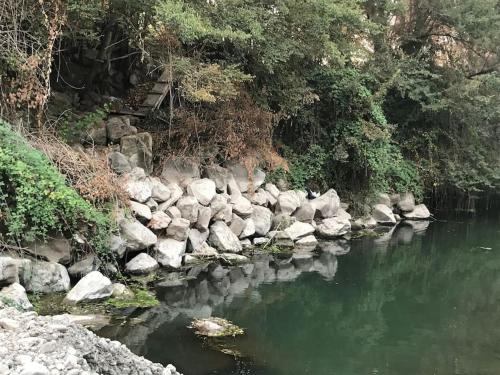 a river with rocks and a staircase in the distance at Casa de campo Santa Cruz in Palmilla