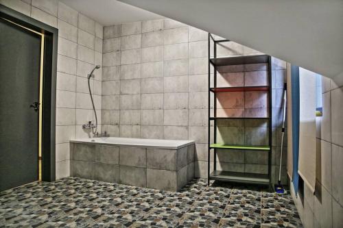 La salle de bains est pourvue d'une baignoire et d'une douche. dans l'établissement Galeria Kolorów pokój rodzinny, à Łódź