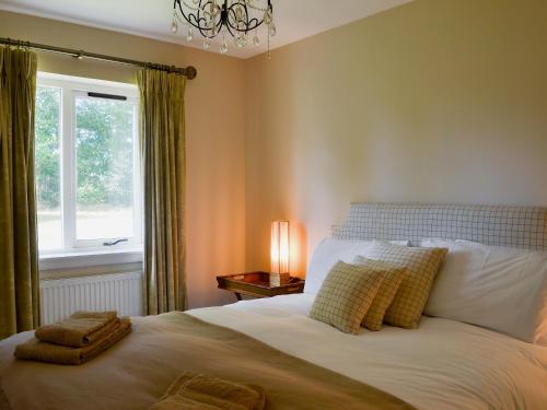 1 dormitorio con 1 cama grande y ventana en Duffs Lodge - Beaufort Estate, en Belladrum