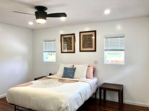 a bedroom with a bed with a ceiling fan at Mākaha House in Waianae