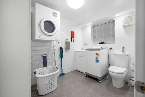 a white bathroom with a toilet and a sink at Almonta Apartments on the water front in Coffin Bay