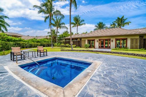 a swimming pool with a table and chairs in front of a house at Mauna Lani KaMilo 217 in Waikoloa