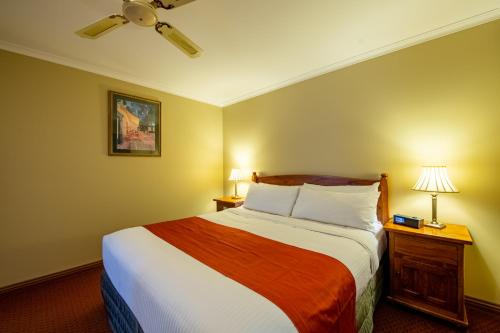 a bedroom with a large bed and two lamps at Gateway on Monash in Clayton North