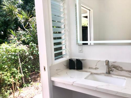 a bathroom with a sink and a mirror at Mākaha House in Waianae