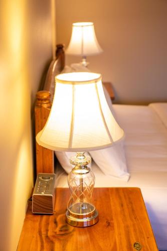 a lamp on a wooden table next to a bed at Gateway on Monash in Clayton North