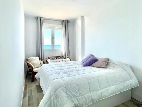 biała sypialnia z łóżkiem i oknem w obiekcie Sea-view apartment in Adra with private terrace w mieście Adra
