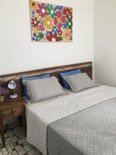 a bedroom with two beds and a painting on the wall at Suites Mar e Lua em casa compartilhada in Ubatuba