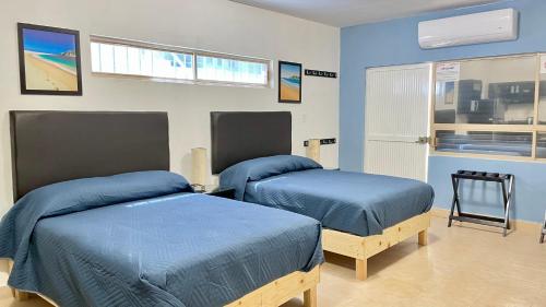 2 Betten in einem Zimmer mit blauen Wänden in der Unterkunft Departamento Loft Ejecutivo Privado Confortable Minisplit Amenidades in Torreón