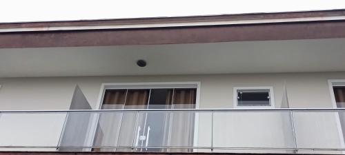 a balcony of a building with two windows at Pousada Floresta in Joinville