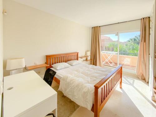 sypialnia z łóżkiem i dużym oknem w obiekcie Apartamento en Los Patios de Santa Maria Golf w Marbelli