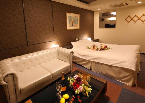 a hotel room with a bed with flowers on it at 福井・鯖江のホテル｜ホテルモーメント in Sabae