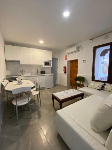 - un salon avec un canapé blanc et une table dans l'établissement Apartamentos Toledo Casa de los Aljibes, à Tolède