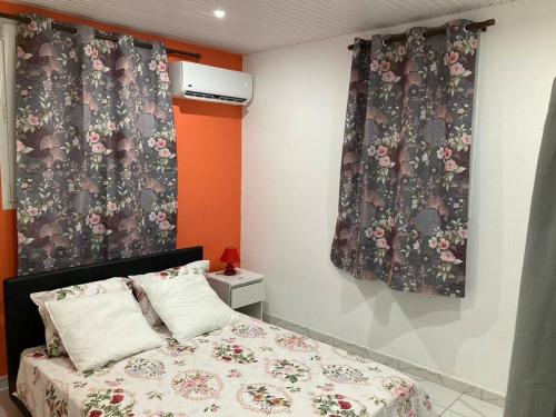 1 dormitorio con 1 cama con colcha de flores en MAHOGANY, en Le Vauclin
