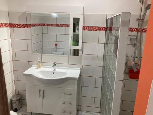 ein weißes Badezimmer mit einem Waschbecken und einem Spiegel in der Unterkunft MAHOGANY in Le Vauclin