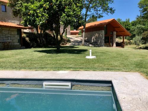 - une piscine dans une cour à côté d'une maison dans l'établissement Vila Alambique, à Bustelo