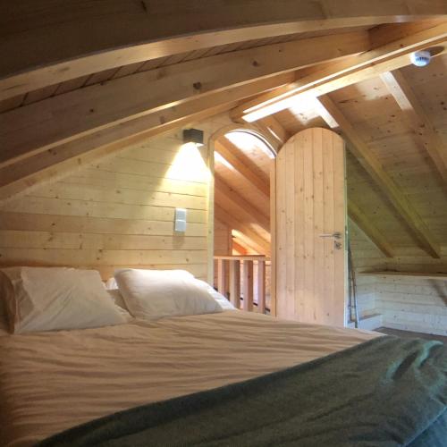 a bed in a room with a wooden wall at Vila Espigueiro I in Bustelo