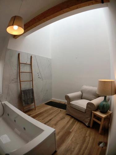 a living room with a couch and a chair at Vila Forno in Bustelo
