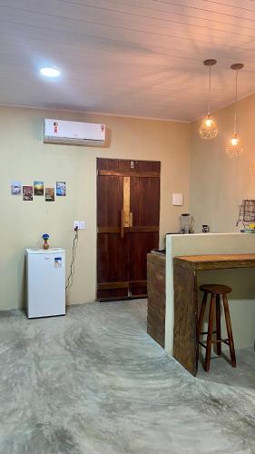 an empty kitchen with a counter and a refrigerator at Milagres Retrô- Studio in São Miguel dos Milagres