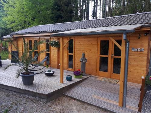 Cabaña de madera pequeña con terraza de madera en Nature et spa, 