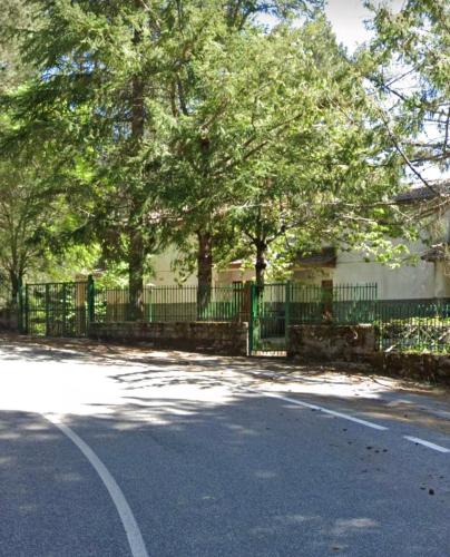 a fence in front of a house with a tree at White’s House in Cutura