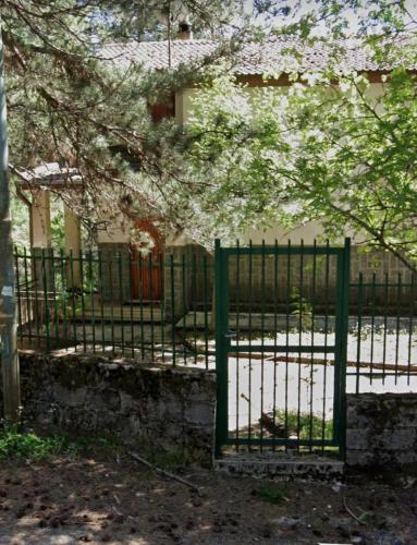 a green metal fence in front of a building at White’s House in Cutura